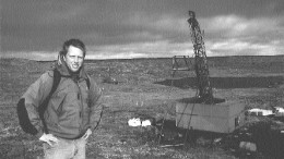 Photo by Thomas SchusterWolfden's project geologist, Ian Neill, stands near a drill rig on the West zone.