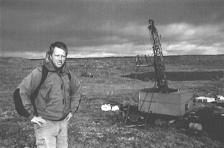 Photo by Thomas SchusterWolfden's project geologist, Ian Neill, stands near a drill rig on the West zone.