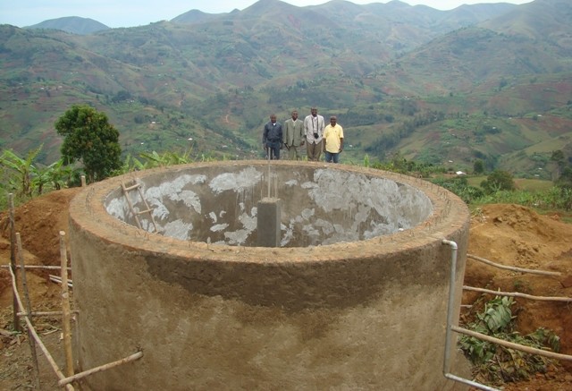 Banro Foundation staff with the tank for a potable water system near the Twangiza gold mine project in the eastern DRC. It serves 18,000 people and consists of 19,000 metres of piping.